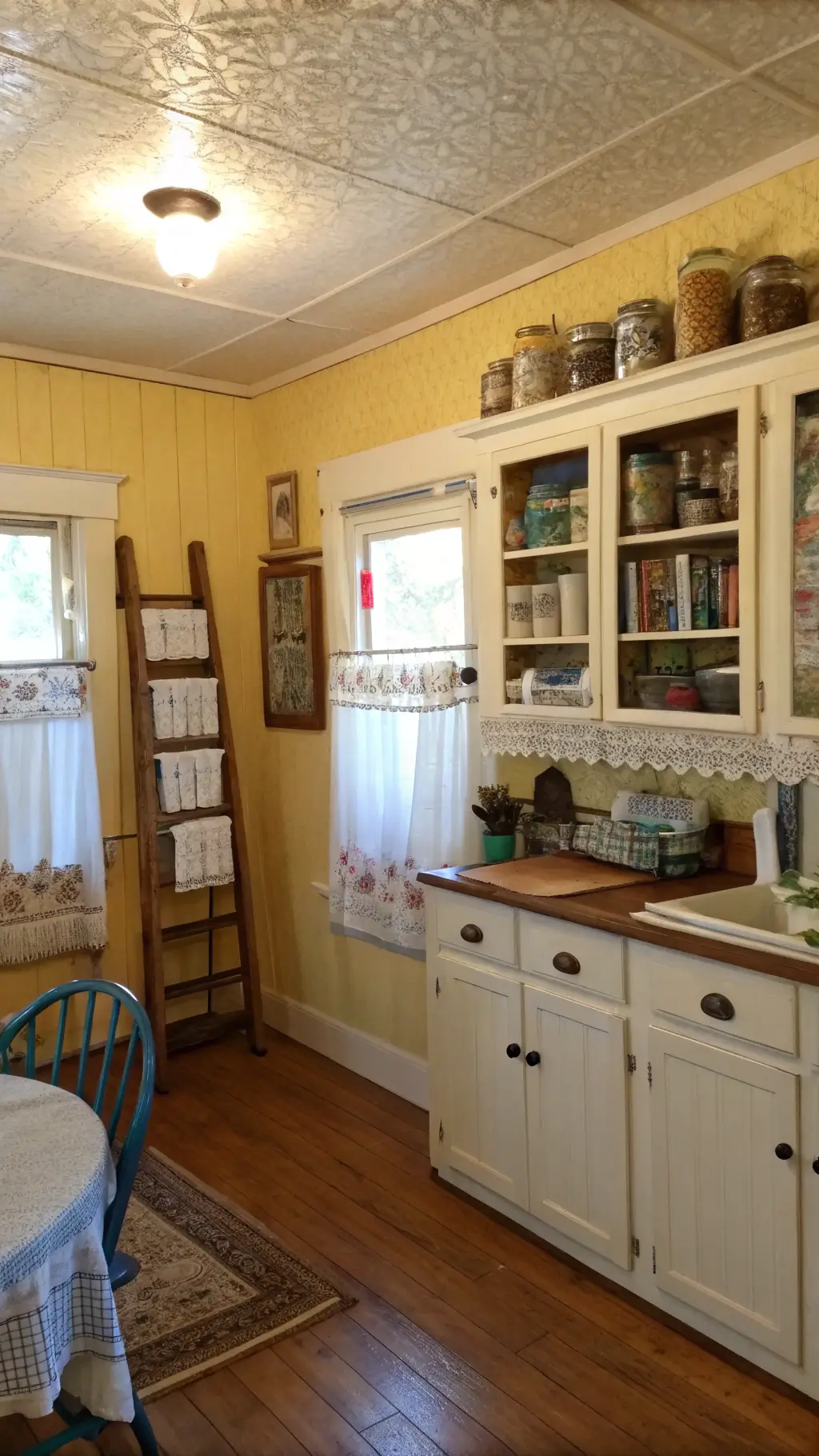 Late afternoon in a warm, yellow 14x16ft kitchen with original hardwood floors, pressed tin ceiling, antique hoosier cabinet, embroidered tea towels on painted rack, blue and white transferware collection, and a stack of worn cookbooks on a wooden chair.
